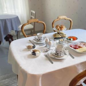 Sauvo的住宿－Vinter Bed & Breakfast，一张白色桌子,上面有杯子和盘子