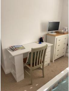 a white desk with a computer and a chair at Burwood House 