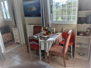stół jadalny z czerwonymi krzesłami, stół i okno w obiekcie Top floor on villa, 3' from center, by the sea! Host is Efi Kwsta w Prewezie