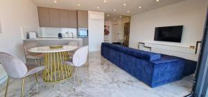 een woonkamer met een blauwe bank en een tafel bij Apartment Eclipse in Opatija