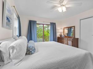 een witte slaapkamer met een bed en een raam bij Honeysuckle Hideaway in Fayetteville
