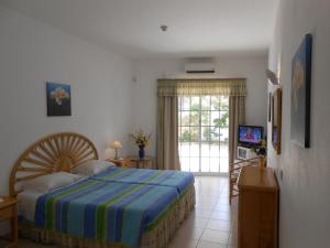 a bedroom with a bed and a sliding glass door at Dona Ana Garden in Lagos