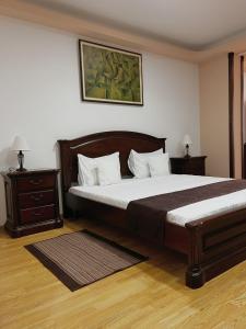 a bedroom with a large bed and two night stands at Hotel Rion in Mangalia