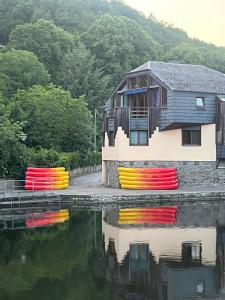 a house with colorfulools next to a body of water at Le repaire des amoureux in La-Roche-en-Ardenne