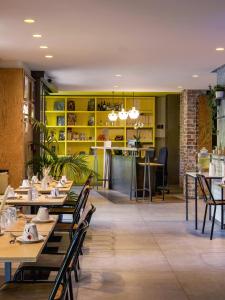 a restaurant with wooden tables and chairs and yellow shelves at Hôtel Gaston in Paris