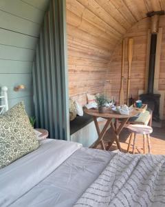 ein Schlafzimmer mit einem Bett und einem Tisch in einem Zimmer in der Unterkunft Skipbridge farm glamping in York