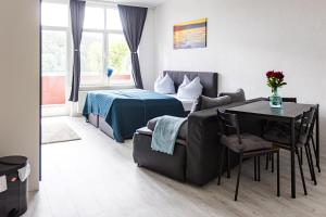 ein Schlafzimmer mit einem Bett, einem Sofa und einem Tisch in der Unterkunft Ferienwohnungen direkt am Werbellinsee in Joachimsthal