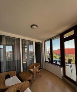 ein Wohnzimmer mit Fenstern und einem Balkon in der Unterkunft Hotel Rion in Mangalia