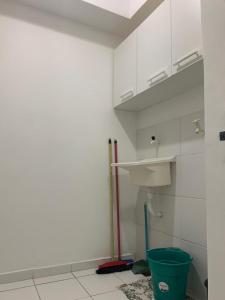 a bathroom with a sink and a green bucket at Apt no Melhor local em Lauro de Freitas in Lauro de Freitas