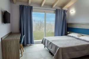 a bedroom with a bed and a large window at Ca' Brichella in Cairo Montenotte