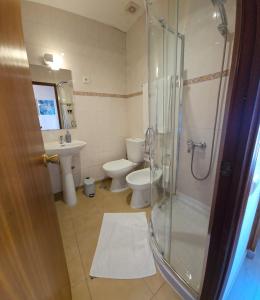 uma casa de banho com um chuveiro, um WC e um lavatório. em Alcamim Guesthouse em Elvas