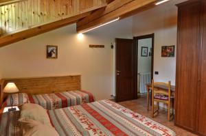 a bedroom with two beds and a wooden staircase at Appartamenti Luseney in Bionaz