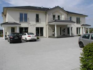 a large white house with cars parked in a parking lot at Lifestyle Beauty & Wellness in Moosbach