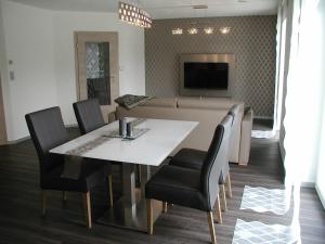a dining room with a table and chairs and a couch at Lifestyle Beauty & Wellness in Moosbach