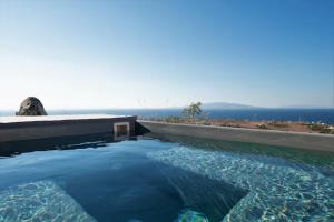 a large pool of water with the ocean in the background at GTK Santorini Oia Sunset Villas in Thólos