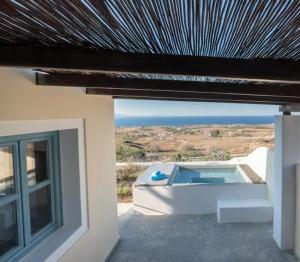 a villa with a pool and a view of the ocean at GTK Santorini Oia Sunset Villas in Thólos