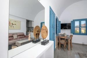 a living room with a table and a dining room at GTK Santorini Oia Sunset Villas in Thólos