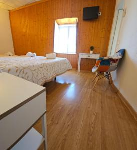 1 dormitorio con 2 camas, escritorio y ventana en Alcamim Guesthouse en Elvas