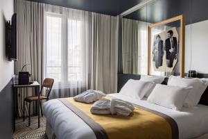 um quarto de hotel com uma cama grande e uma janela em Hôtel Gaston em Paris