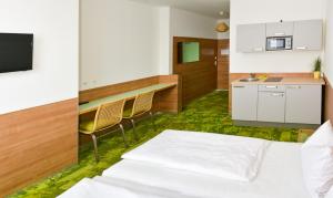 1 dormitorio con 1 cama blanca y cocina en 24seven Apartments - Self Check-IN, en Landshut
