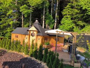 a large wooden cabin with a deck in the woods at Au Doubs Kota 