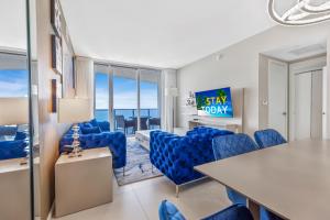 a living room with blue chairs and a table at The Ultimate Resort - BEACHFRONT 2 BEDROOM APARTMENT WITH DIRECT OCEAN VIEW, ROOFTOP POOL, HOT TUB AND GYM in Hollywood