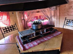 a stove with a pot on top of it on a table at Au Doubs Kota in Montlebon