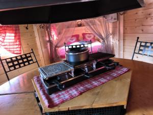 a stove with a pot on top of it on a table at Au Doubs Kota 