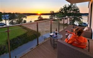 dwoje osób siedzących na balkonie obserwujących zachód słońca w obiekcie Perfect View - najlepszy widok w Iławie plus garaż podziemny, winda, Netflix w Iławie