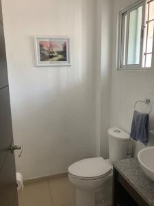 a white bathroom with a toilet and a sink at Casa acogedora frente a parque 2000 pegaso, Frac. Las Misiones 1 in Toluca