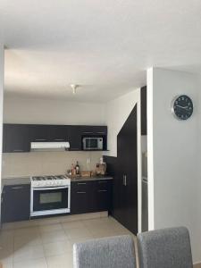 a kitchen with black cabinets and a stove top oven at Casa acogedora frente a parque 2000 pegaso, Frac. Las Misiones 1 in Toluca