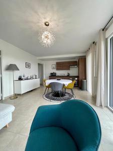 sala de estar con sofá azul y mesa en BELLA CRUZ 66 m2 prestations premium, wifi, balcon, parking avec borne de recharge électrique, plage Prieuré, Commerces en Dinard