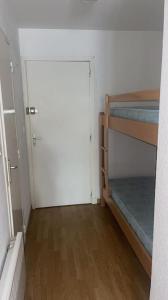 Cette chambre comprend 2 lits superposés et une porte. dans l'établissement Magnifique studio en bord de mer, à Calvi