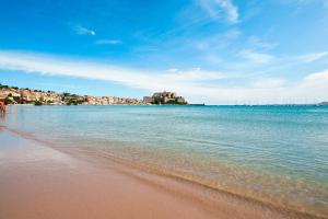 - une vue sur une plage avec des bâtiments au loin dans l'établissement Magnifique studio en bord de mer, à Calvi 2 autres photos