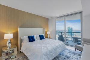 una camera da letto con un letto grande e una grande finestra di The Ultimate Resort - BEACHFRONT 2 BEDROOM APARTMENT WITH DIRECT OCEAN VIEW, ROOFTOP POOL, HOT TUB AND GYM a Hollywood