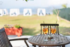 カボスにあるSandy Beach Houses - Sea Viewの木製テーブルに座るワイングラス2杯