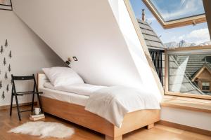 a bed in a room with a window at Mountain Base - Dwupoziomowy apartament "Przy lesie II" z prywatnym jacuzzi w Kościelisku in Kościelisko