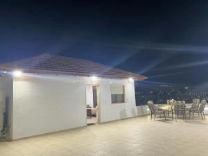 eine Terrasse mit einem Tisch und Stühlen in der Nacht in der Unterkunft Aida Magic of Nazareth - Guesthouse in Nazareth