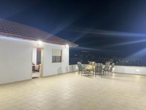 eine Terrasse mit einem Tisch und Stühlen auf dem Balkon in der Unterkunft Aida Magic of Nazareth - Guesthouse in Nazareth