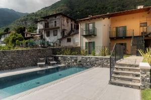 a house with a swimming pool next to a building at Corte Masnate "Grigio" by LoveComo in Lenno
