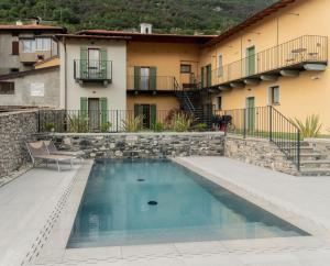 a swimming pool in front of a building with a house at Corte Masnate - Grigio in Lenno