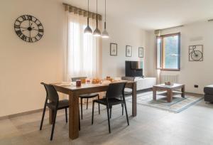 a dining room with a table and chairs and a clock at Corte Masnate "Grigio" by LoveComo in Lenno