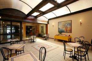 a dining room with tables and chairs in a building at Hotel Plaza in Taranto