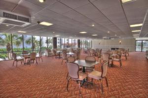 uma grande sala com mesas, cadeiras e janelas em El Matador 539 - Third floor unit em Fort Walton Beach