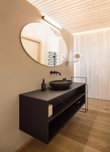 a bathroom with a black sink and a mirror at HOLZGAUER HAUS in Warth am Arlberg