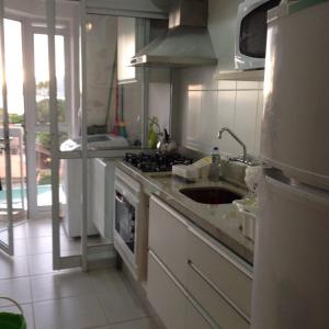 a kitchen with a sink and a stove at Nautilus Paraíso Tropical - Vista ao Mar in Penha