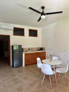 een keuken met een tafel en stoelen en een koelkast bij La Casa del Sol Holbox in Holbox Island