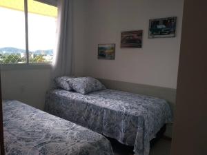 a bedroom with two beds and a window at Nautilus Paraíso Tropical - Vista ao Mar in Penha