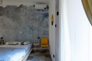 ein Schlafzimmer mit einem Bett und einem gelben Stuhl in der Unterkunft Awensome Apartment in front of Vatican Museums - myDen in Rome in Rom