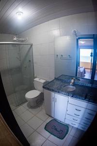 a bathroom with a toilet and a shower and a sink at Aqua Villa by Garvetur in Beberibe
